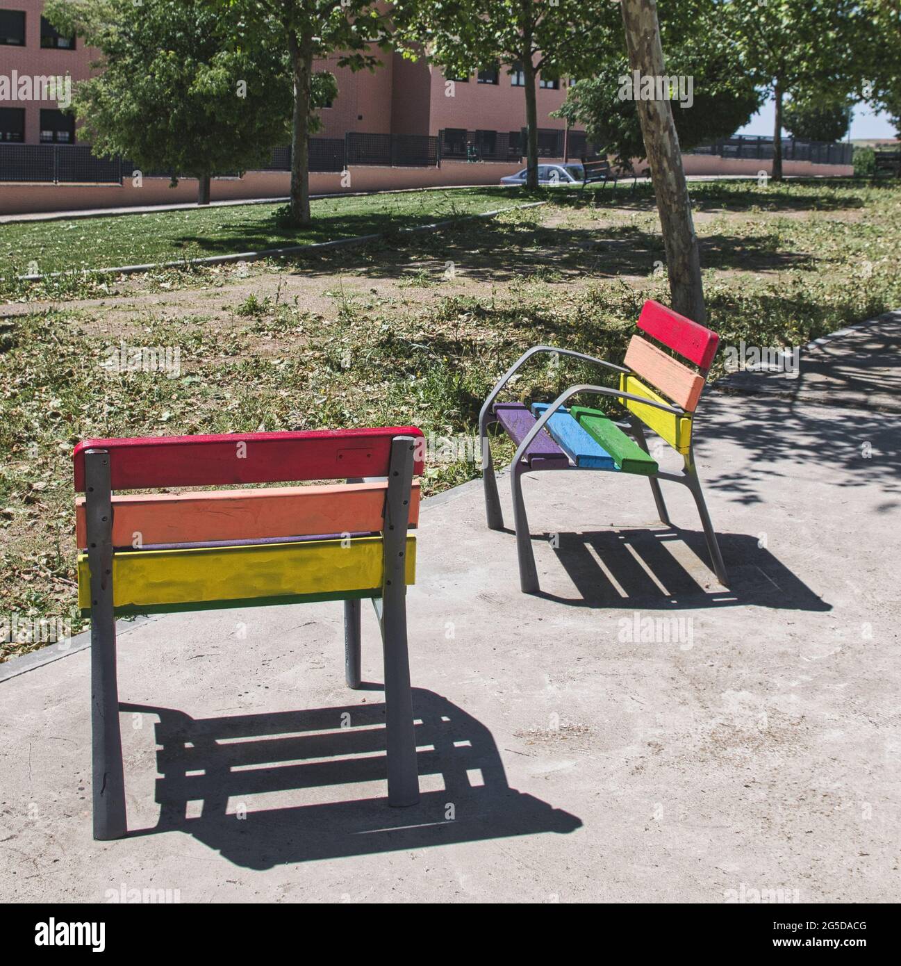 Benches with pride flag colors in the park Stock Photo - Alamy