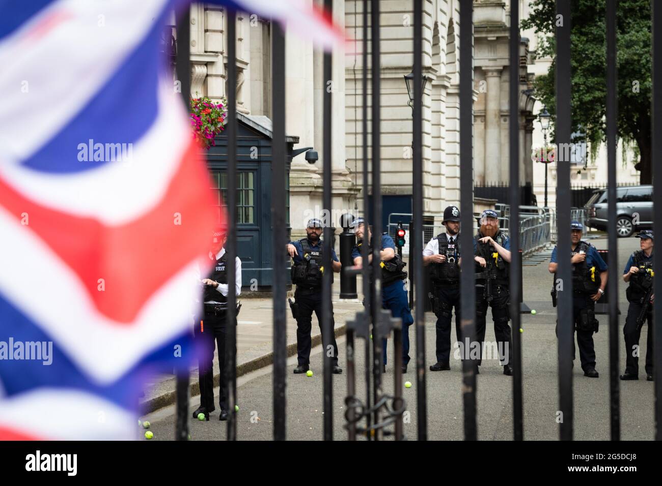 London, UK. 26th June, 2021. Police stand guard at Downing Street while a anti-lockdown protest passes. Thousands of people marched to raise their concerns regarding government legislation centred around vaccinations and freedom to travel.ÊAndy Barton/Alamy Live News Credit: Andy Barton/Alamy Live News Stock Photo