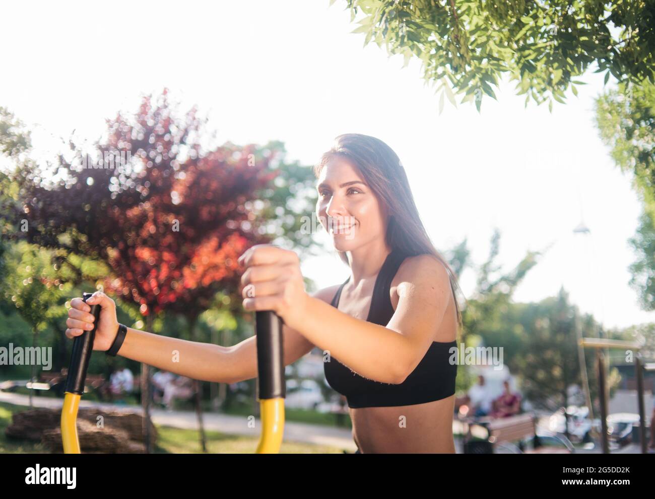 Healthy fit woman in sport clothes doing exercise on outdoors exercise machine Stock Photo
