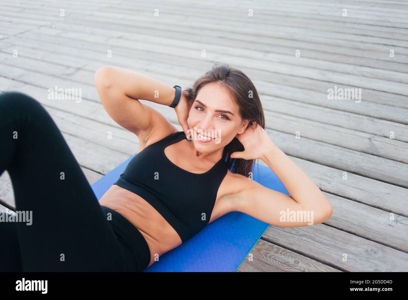 Fit woman doing lateral twisting exercises for abdominal muscles lying ...
