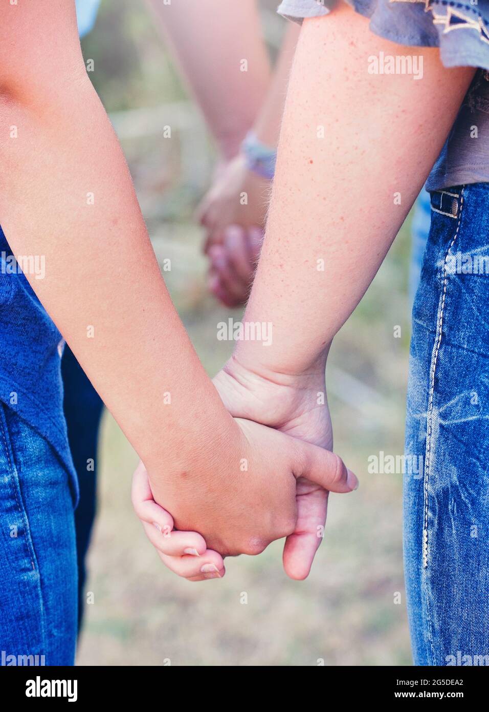 Group of People Praying in a Circle Holding Hands Stock Photo