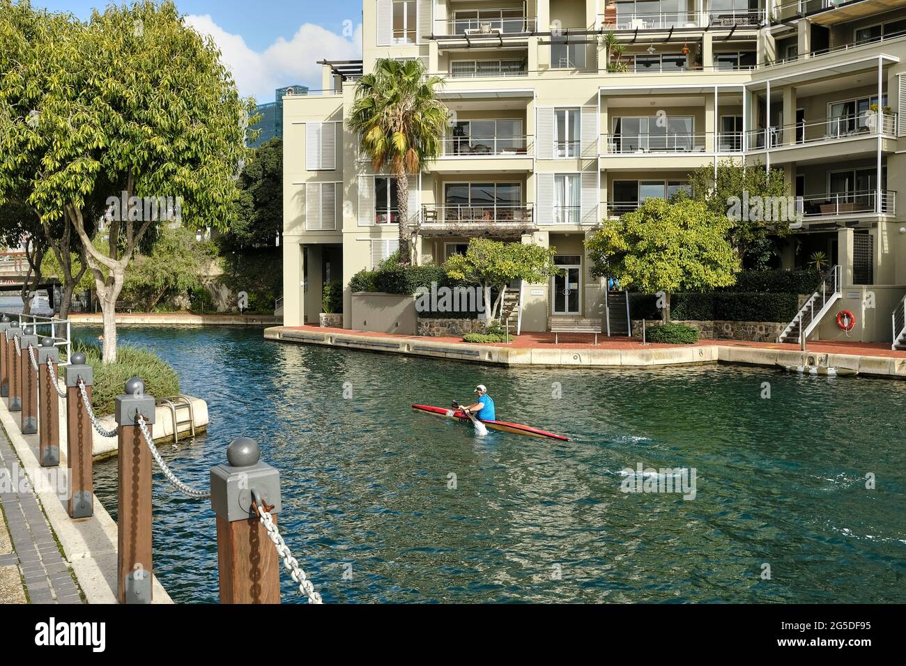 A man rowing on the water canal in the V&A Marina - Waterfront in Cape Town, South Africa. Stock Photo