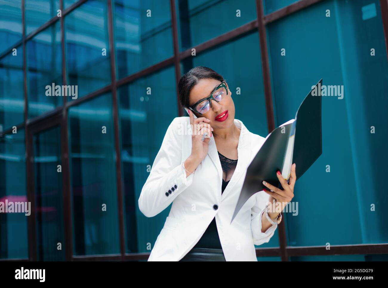 Professional business afro woman in elegant white jacket and skirt with ...