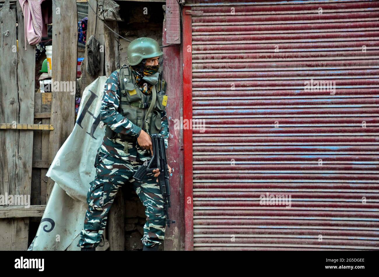 Srinagar, India. 26th June, 2021. A trooper takes position after a grenade attack on security post in Srinagar. Three civilians were injured in a grenade attack after suspected militants lobbed a grenade at a joint team of security forces in Srinagar, officials said. Credit: SOPA Images Limited/Alamy Live News Stock Photo
