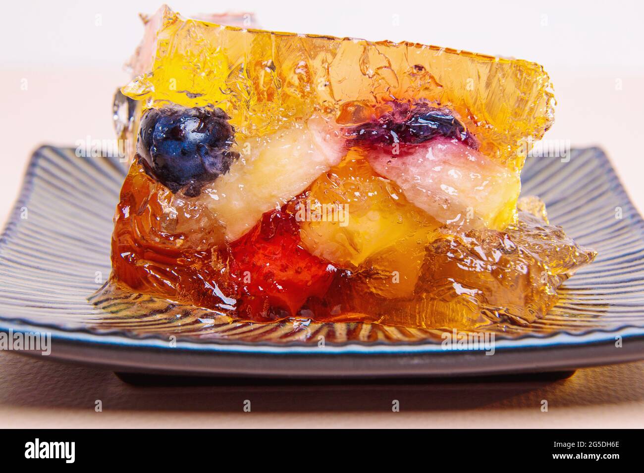 Jelly from different fruits and berries on a square saucer. Dessert. Close-up Stock Photo