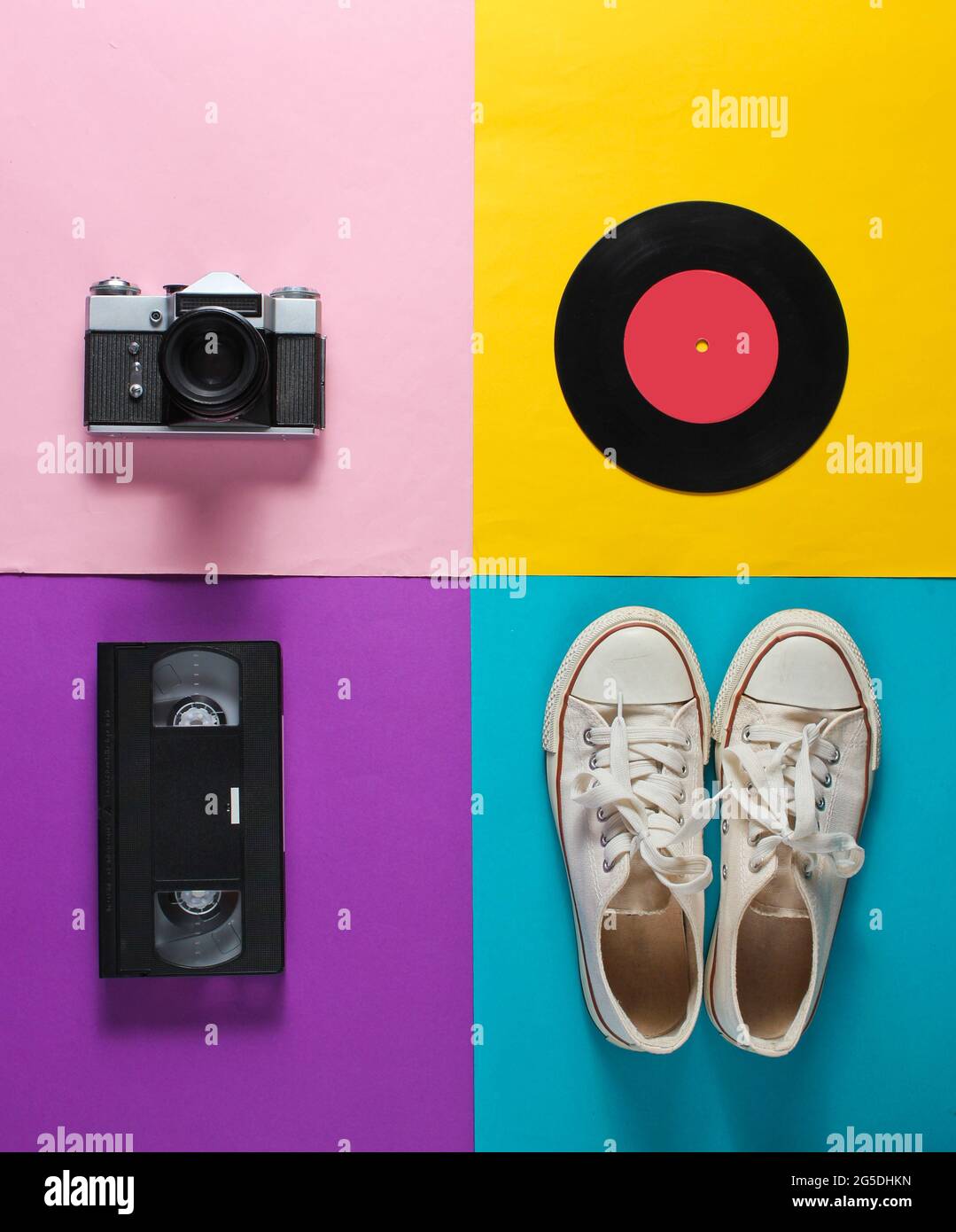 https://c8.alamy.com/comp/2G5DHKN/retro-still-life-old-fashioned-sneakers-vinyl-record-vintage-film-camera-video-cassette-on-colored-background-top-view-pop-art-flat-lay-2G5DHKN.jpg