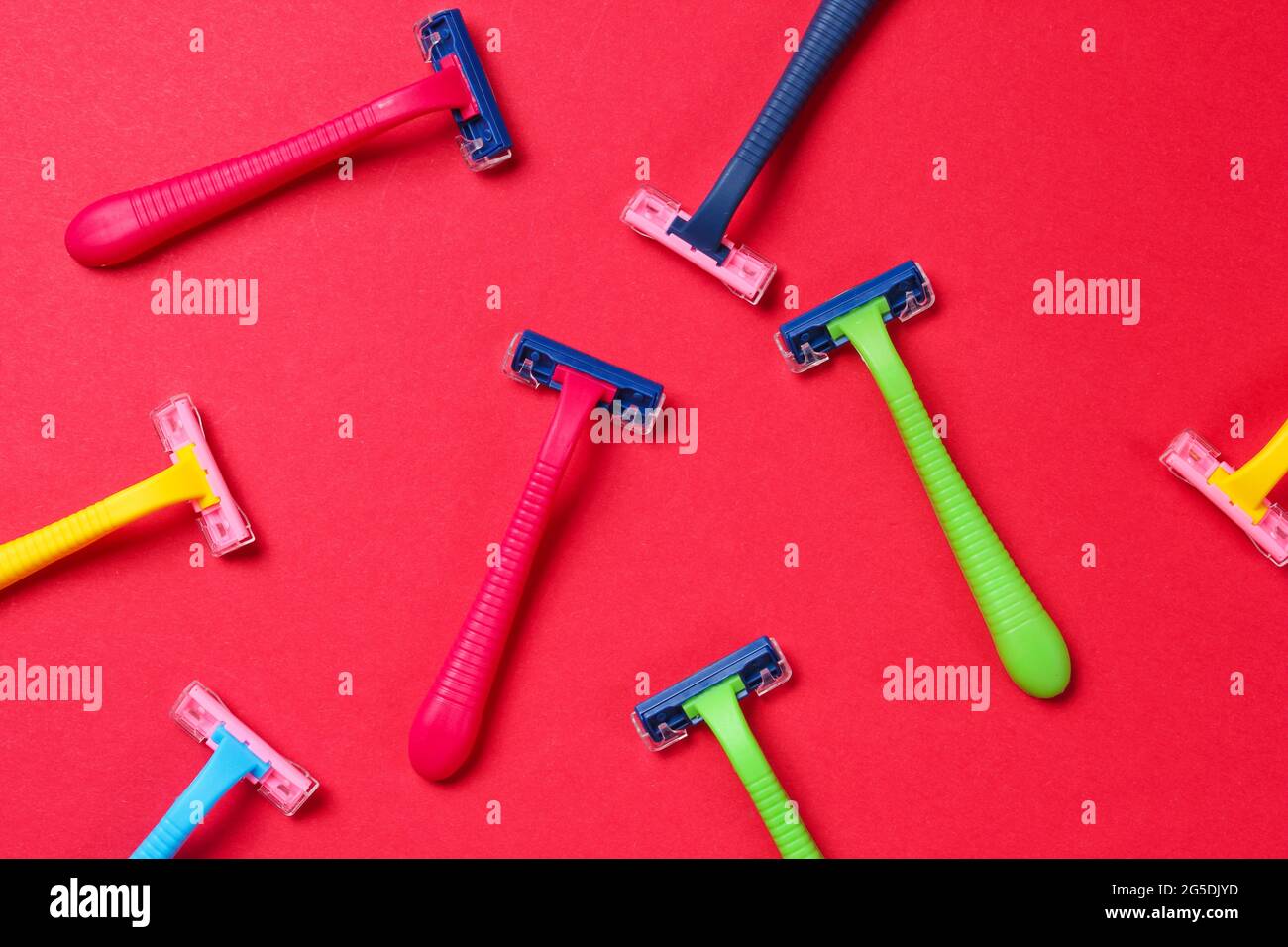 Beauty and fashion pop art concept. Many colored plastic razors on red ...