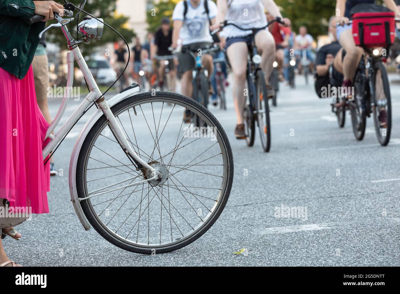 front wheel of a women’s bike in the foreground of a critical mass Stock Photo