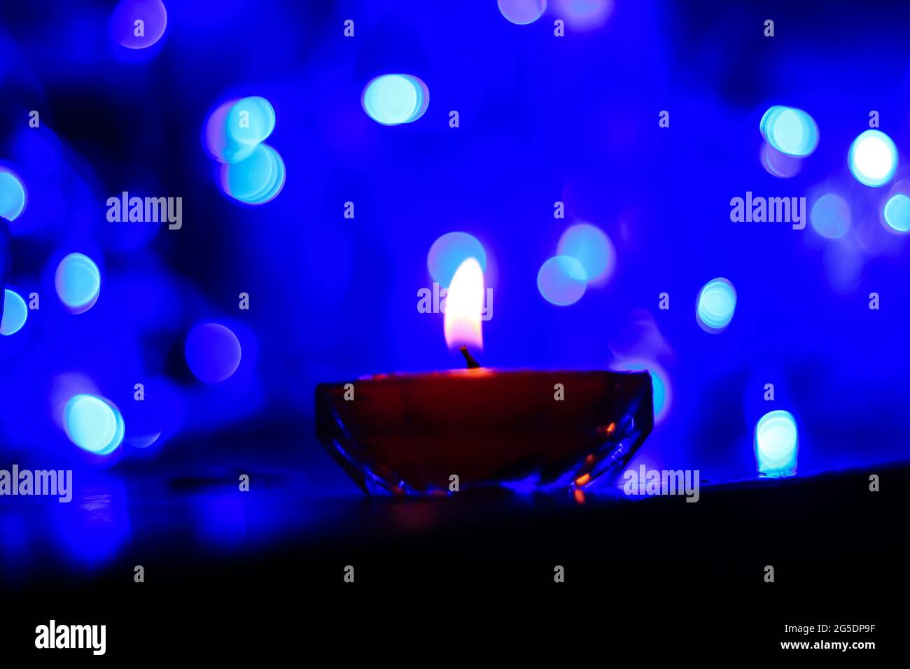 Candle lights in darkness with colorful light effects and bokeh for