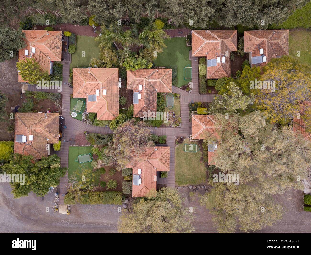 Aerial view of rural residential area with private homes between green fields. Stock Photo
