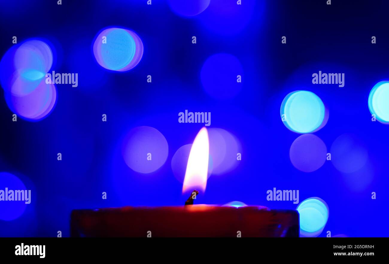 Candle lights in darkness with colorful light effects and bokeh for