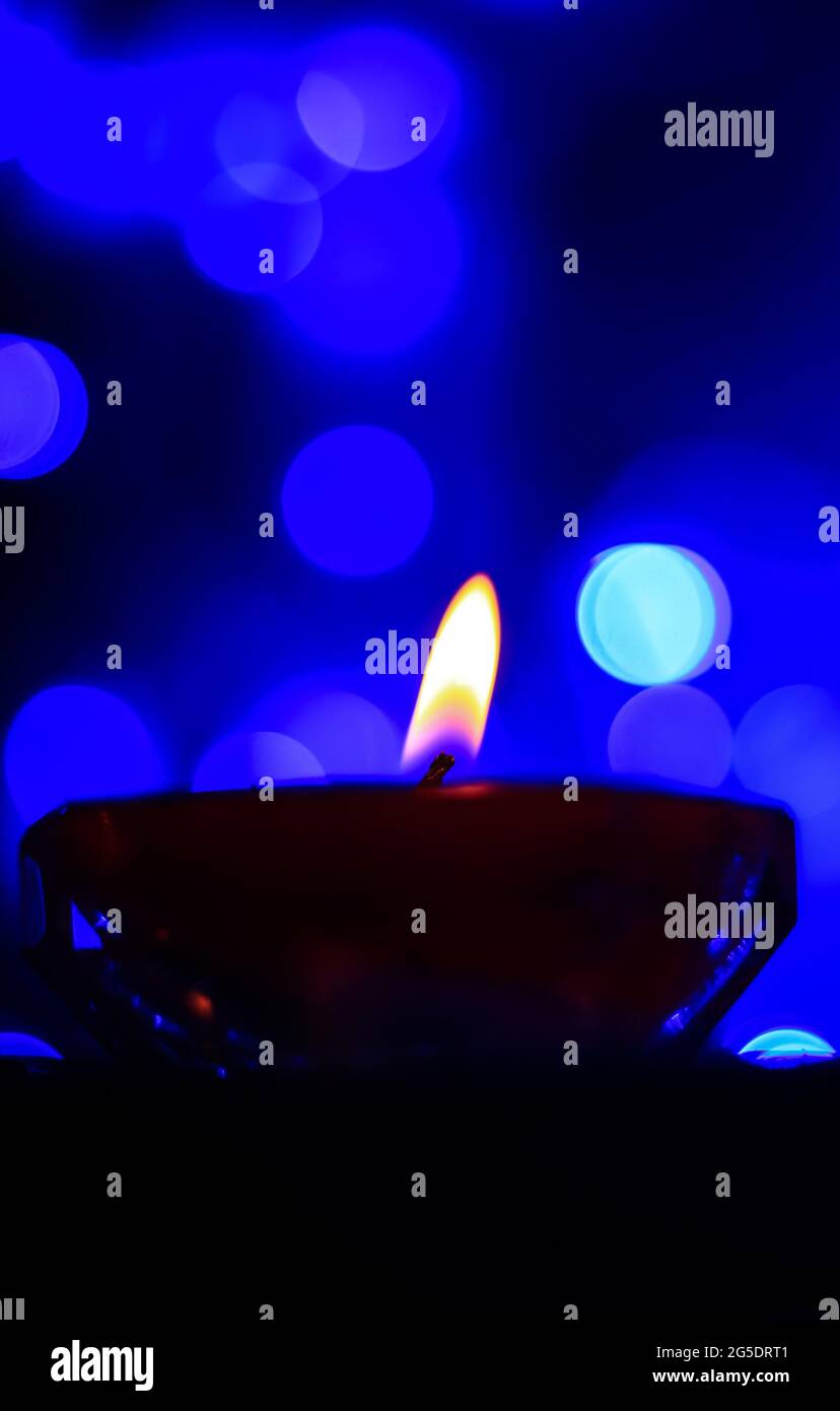 Candle lights in darkness with colorful light effects and bokeh for