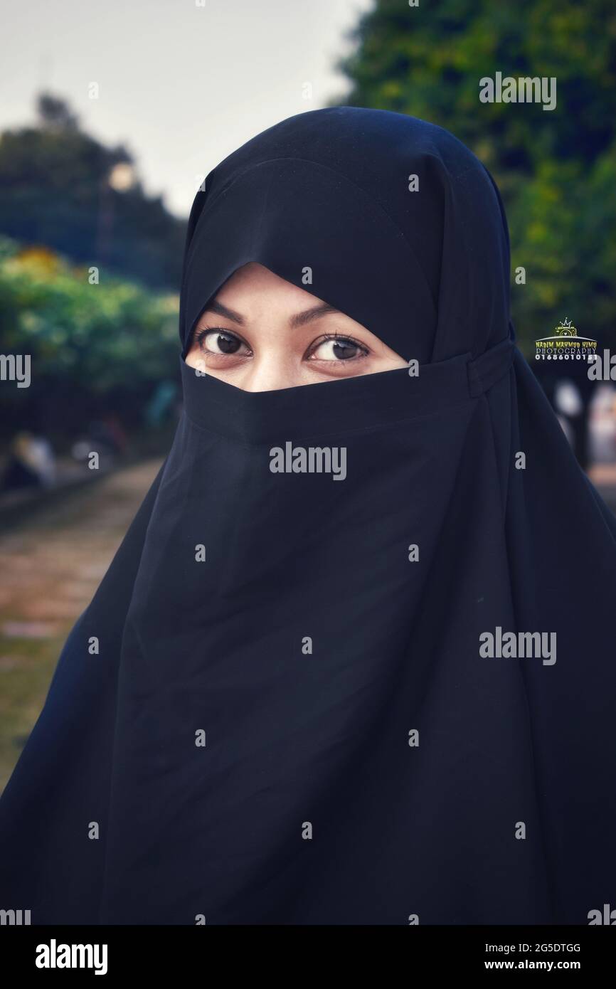 Closeup of beautiful woman face covered with hijab. Perfect shiny eyes of a Muslim girl. Young niqab girl portrait with the background. Stock Photo