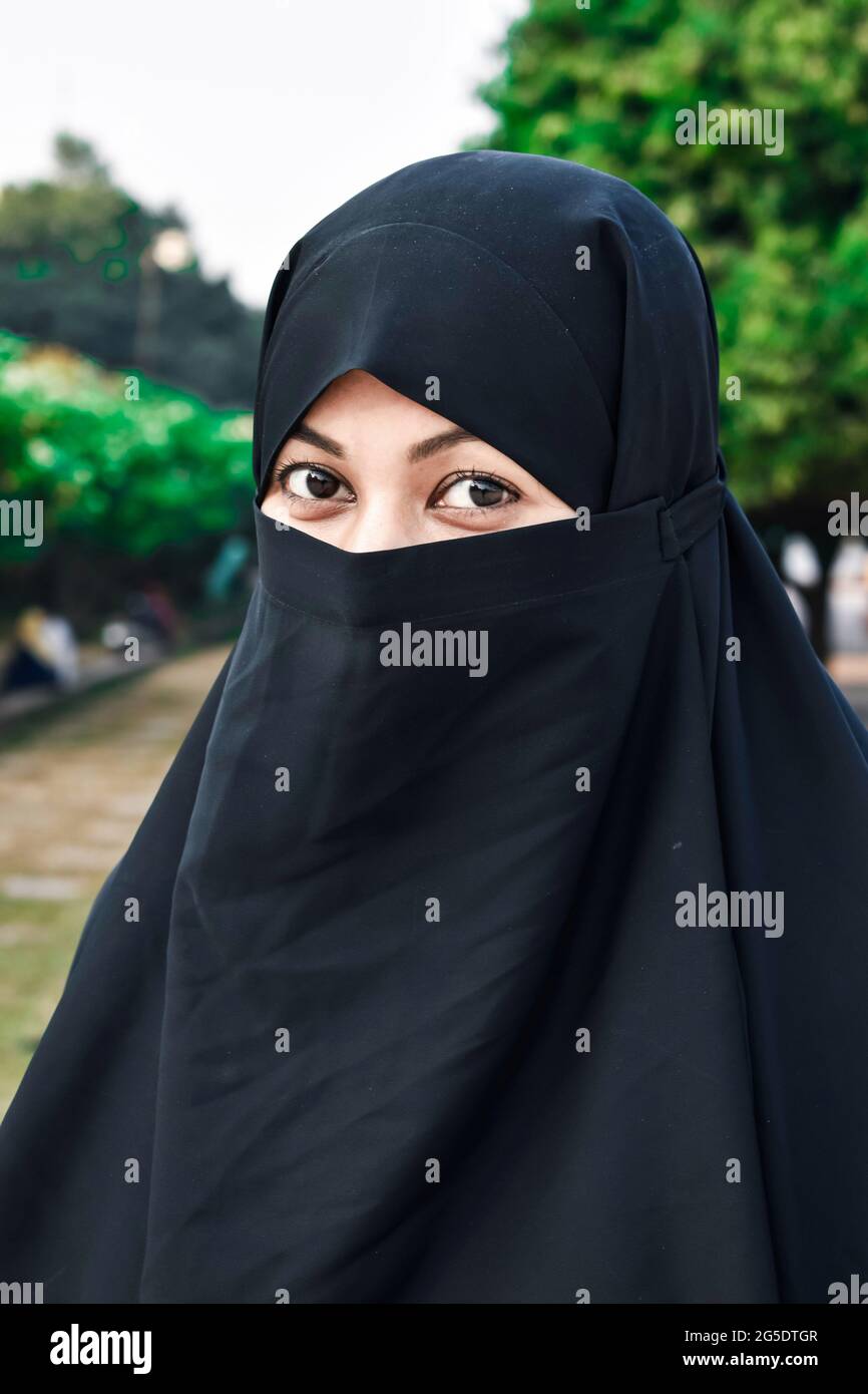 Closeup of beautiful woman face covered with hijab. Perfect shiny eyes of a Muslim girl. Young niqab girl portrait with the background. Stock Photo