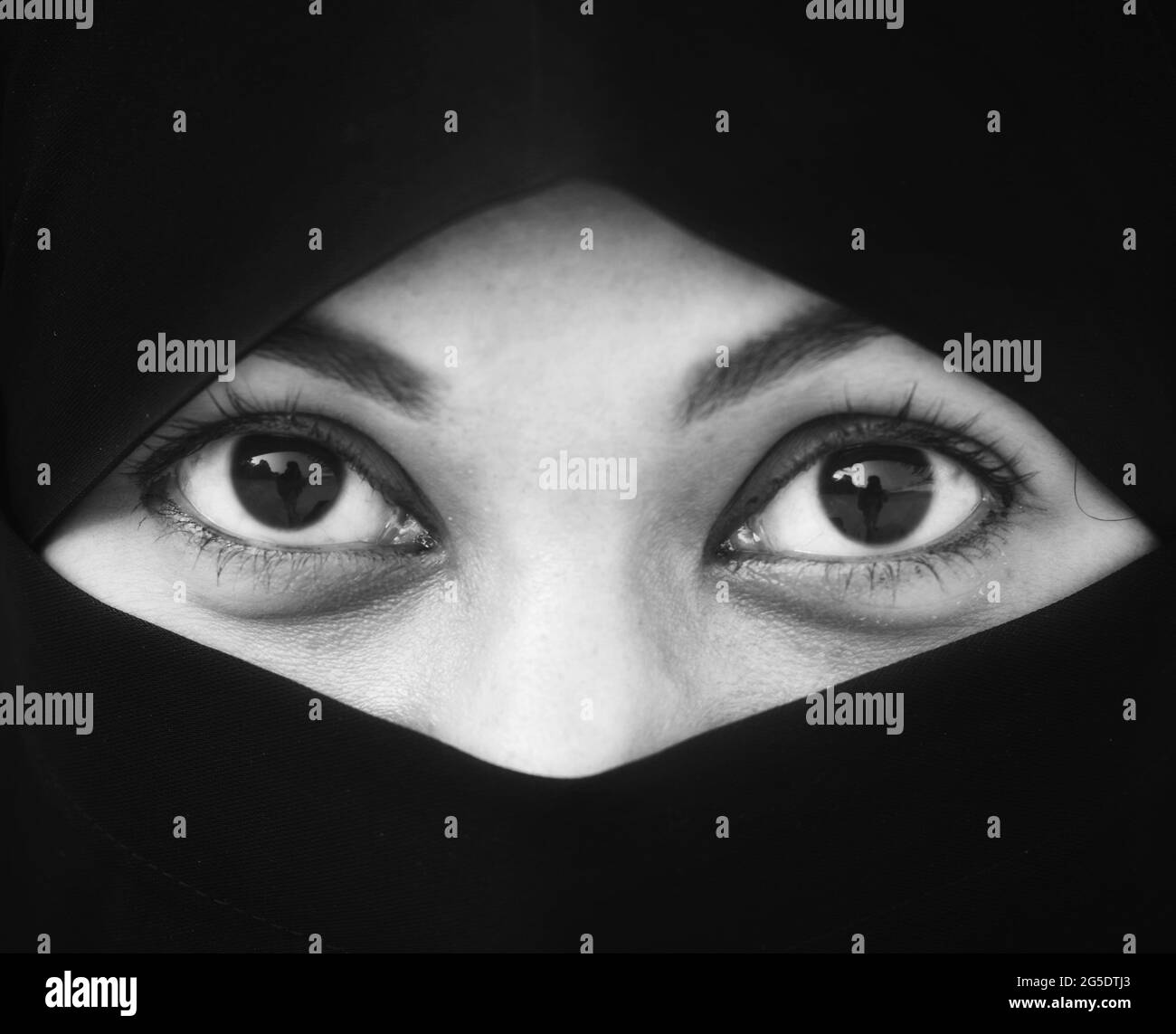 Closeup of beautiful woman face covered with hijab. Perfect shiny eyes of a Muslim girl. Young niqab girl portrait. Stock Photo