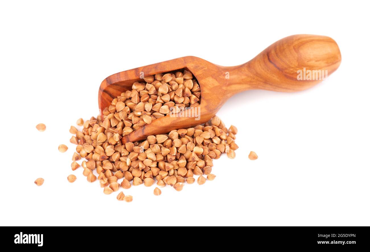 Roasted buckwheat grains in olive scoop, isolated on white background