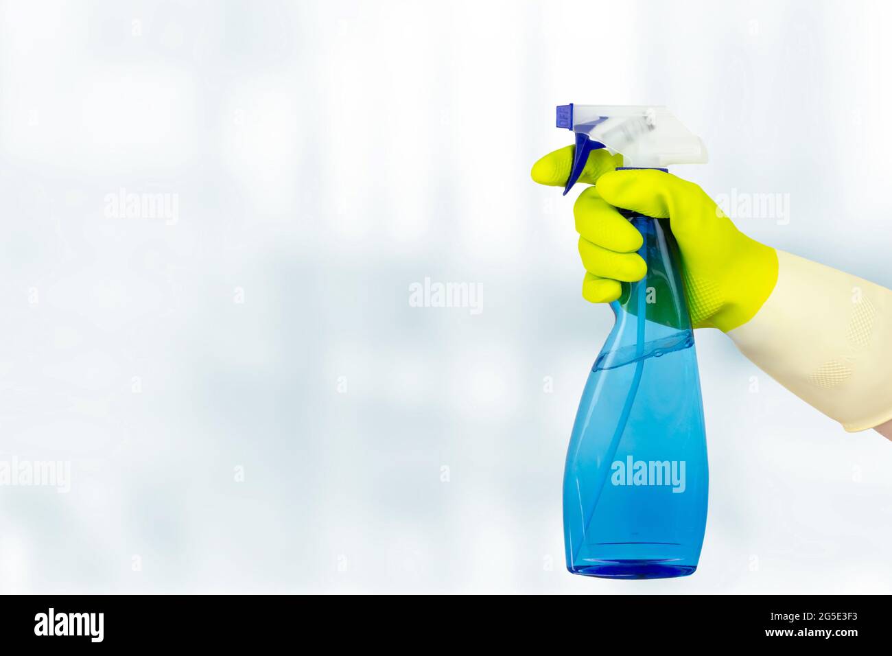 Spring cleaning concept. Hand Holding Spray Bottle. Woman holding bottle of detergent on white background. General or regular cleanup Stock Photo