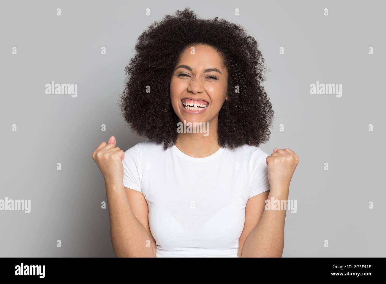 Portrait of overjoyed biracial woman celebrate success Stock Photo