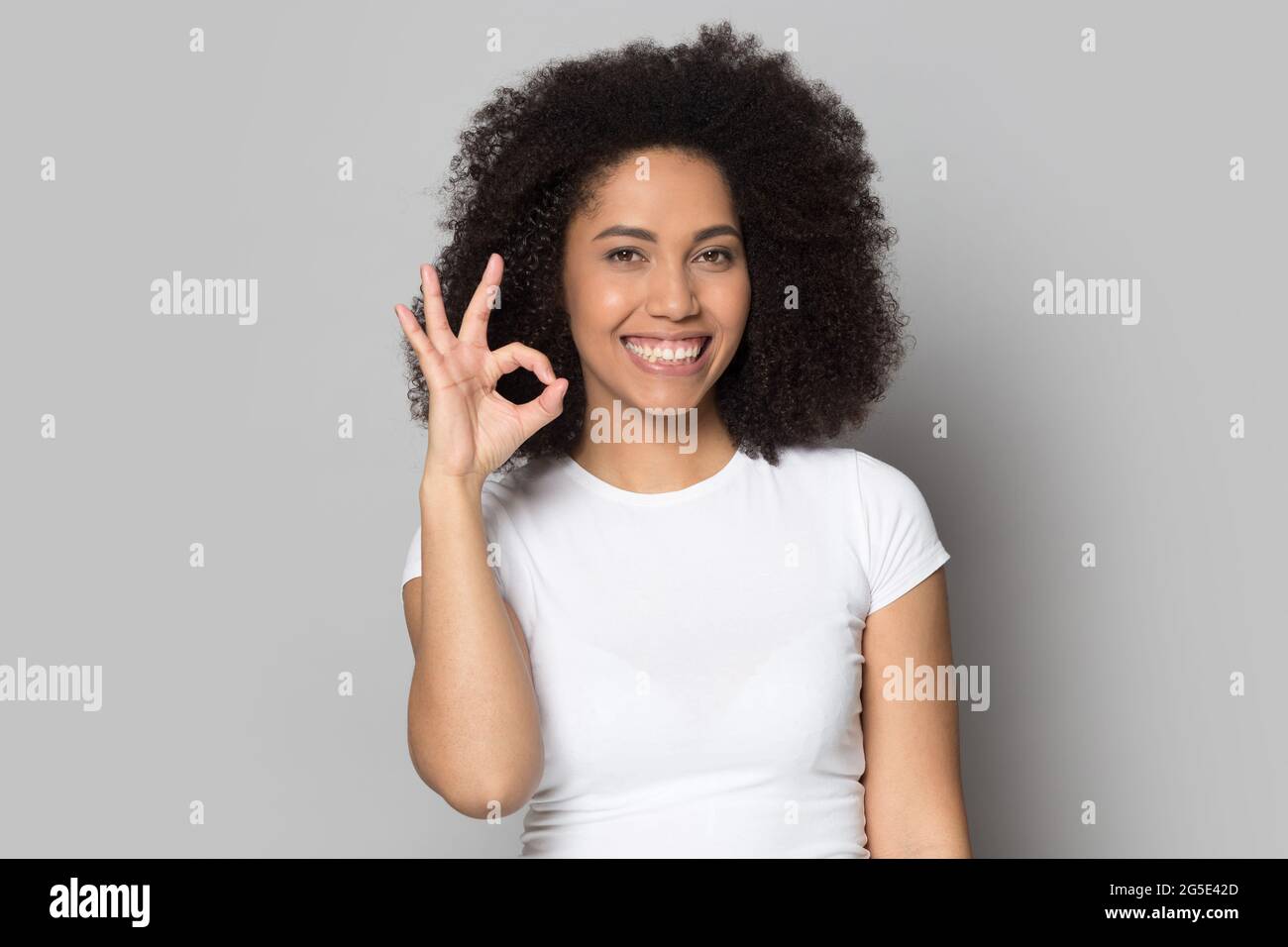 Portrait of smiling mixed race woman show ok hand gesture Stock Photo