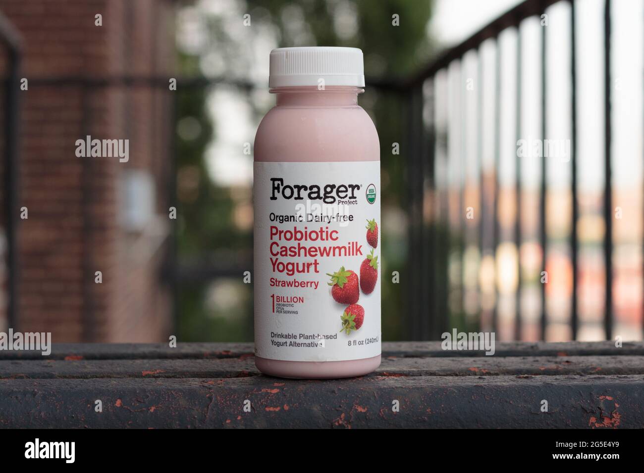 bottle of strawberry flavored organic dairy-free probiotic cashewmilk drinkable yogurt by the Forager Project brand, on a fire escape Stock Photo