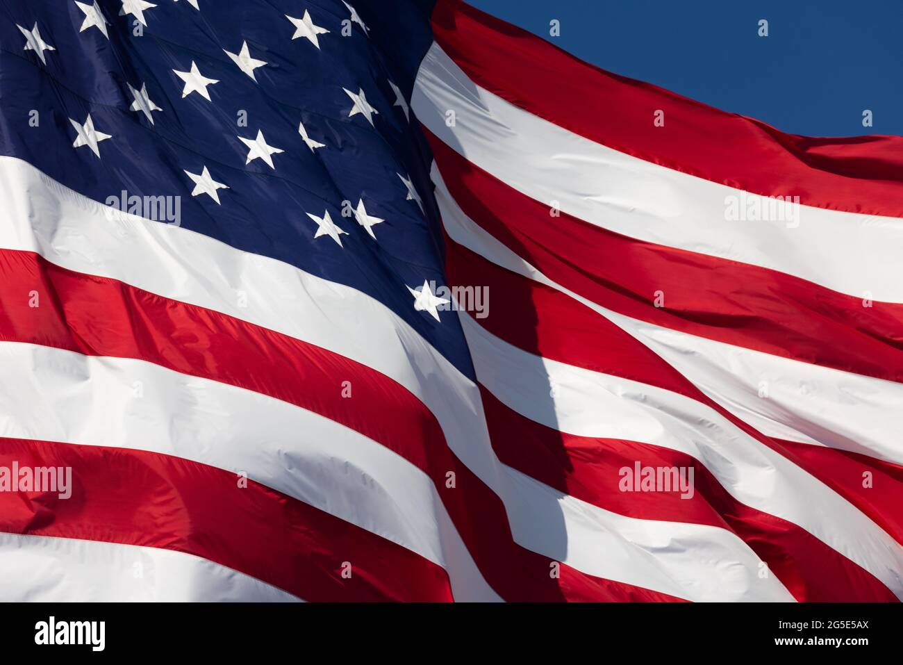 American Flag Waving In Wind Against a Deep Blue Sky Stock Photo - Alamy
