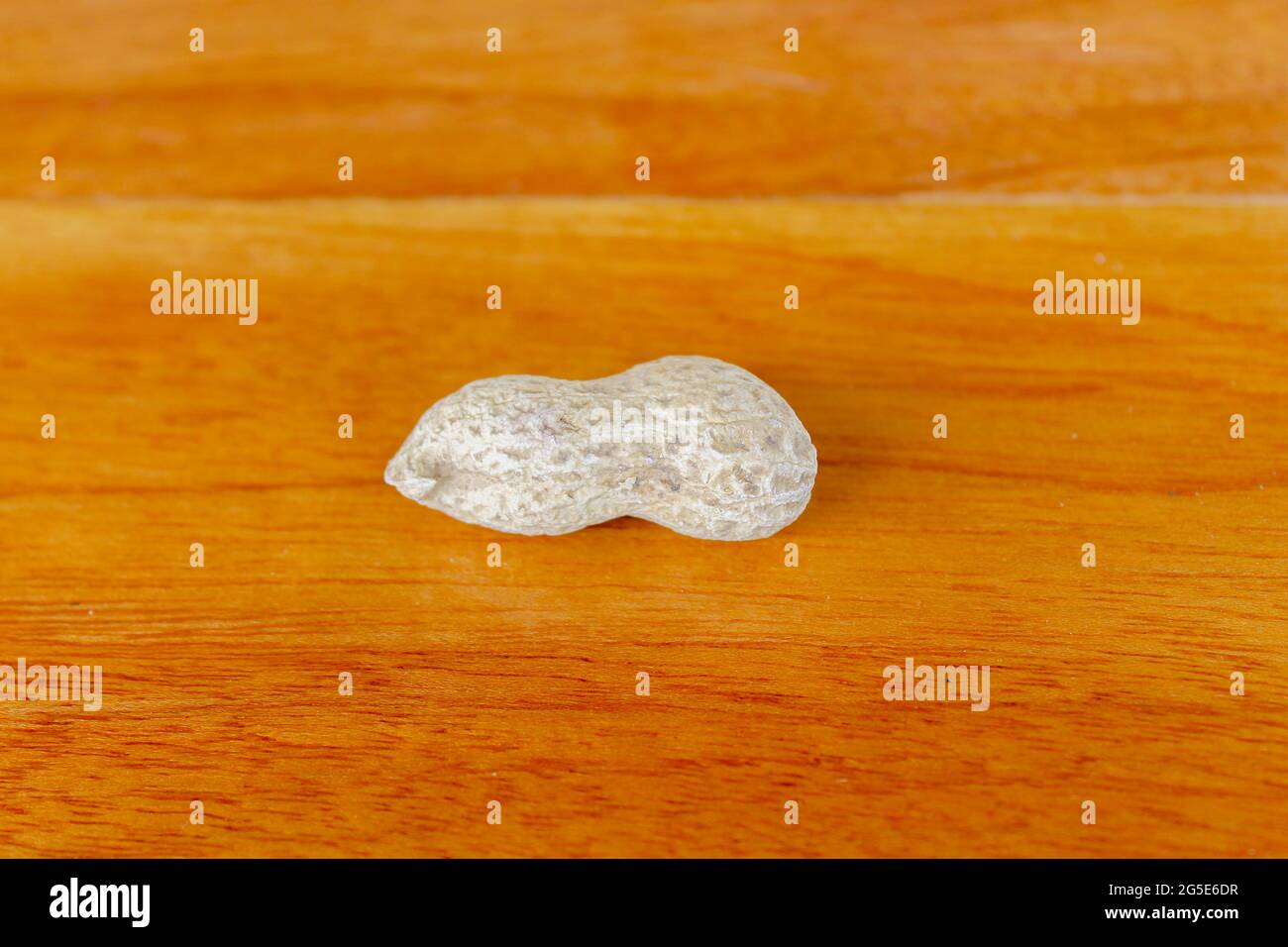 Peanuts on a wooden table. A peanut is placed on a wooden table overlooking the wood grain. Stock Photo