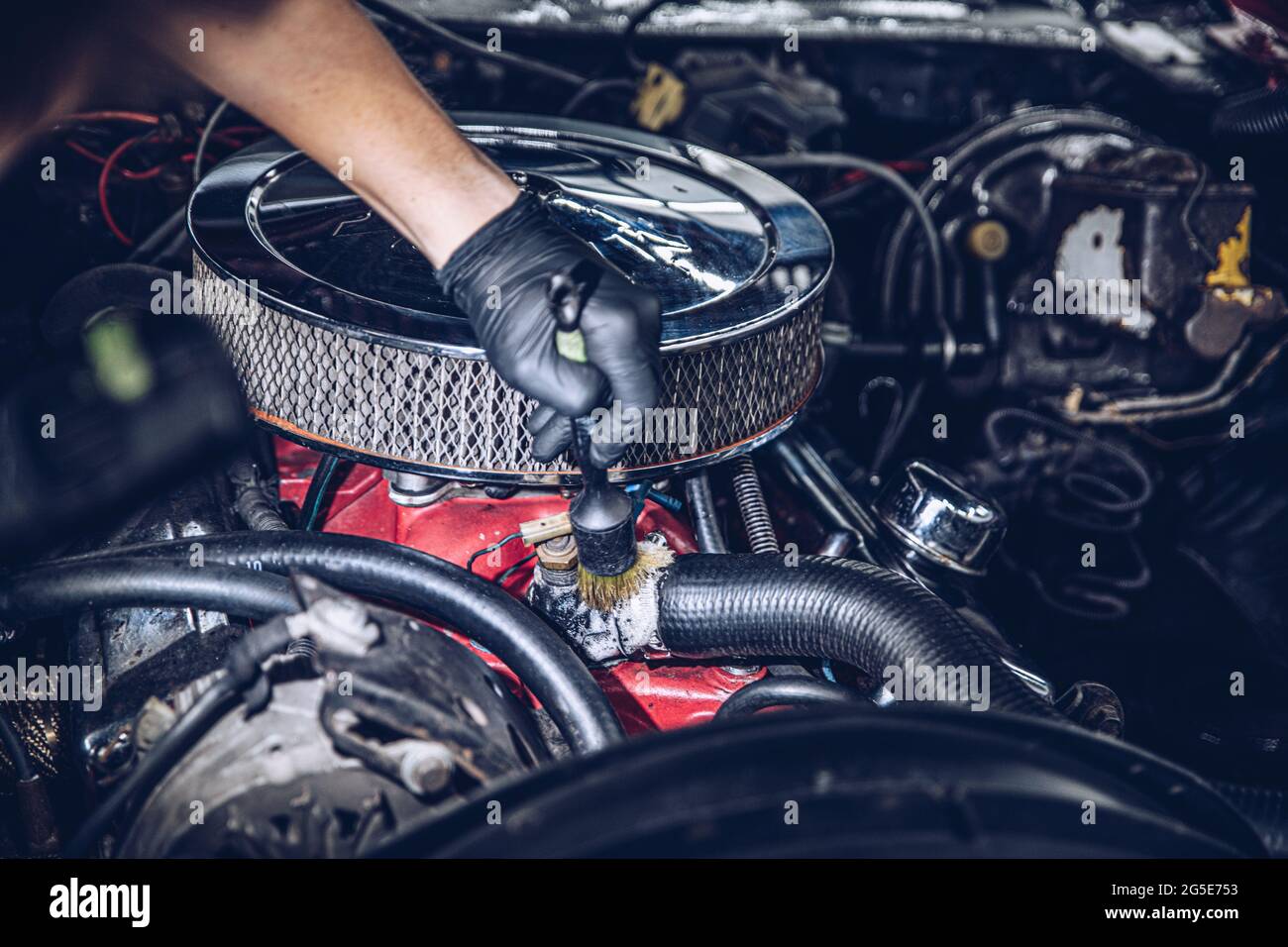 Car detailing studio worker cleaning classic car engine Stock Photo Alamy