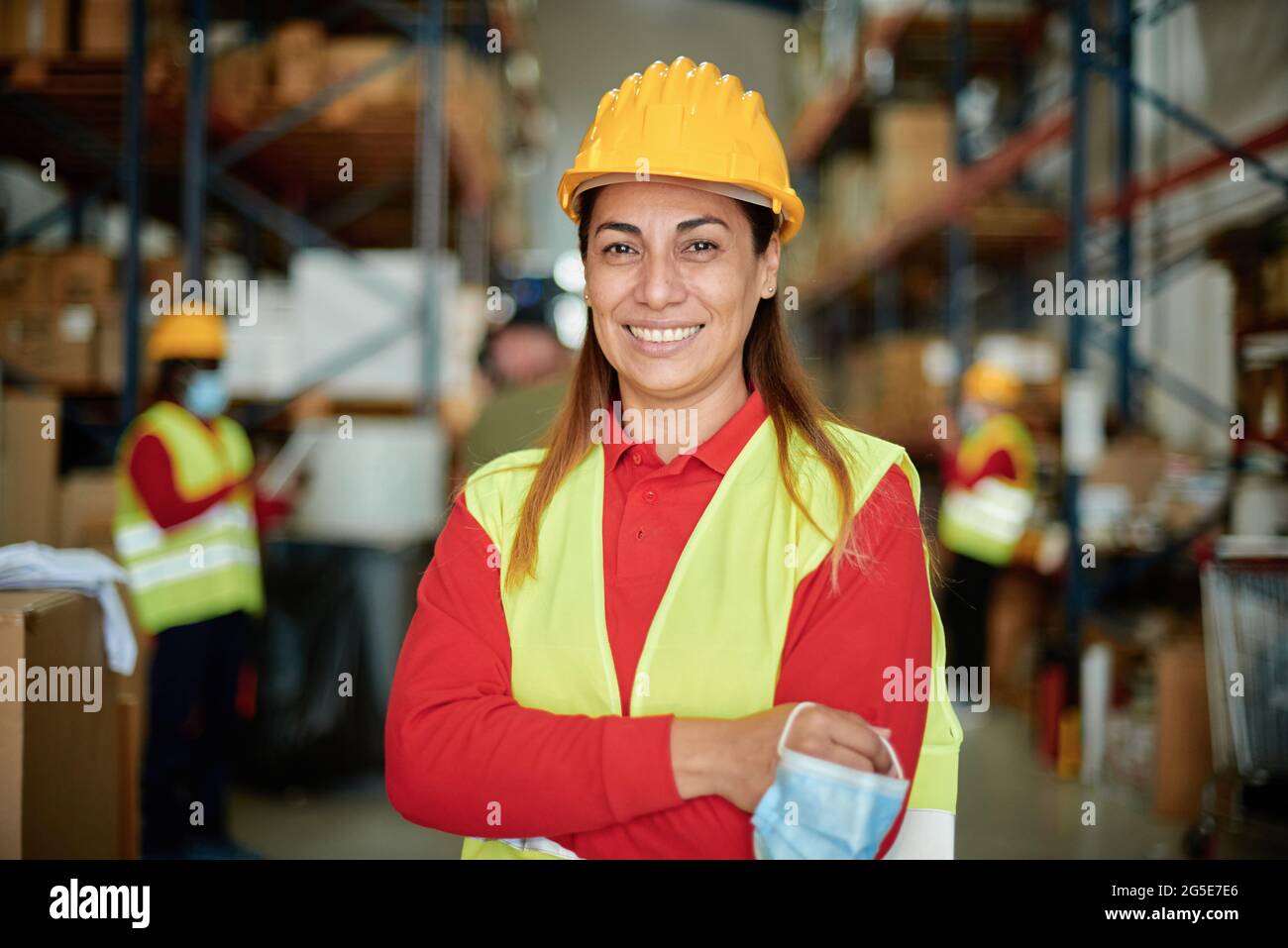 Smiling female warehouse worker looking at camera Stock Photo