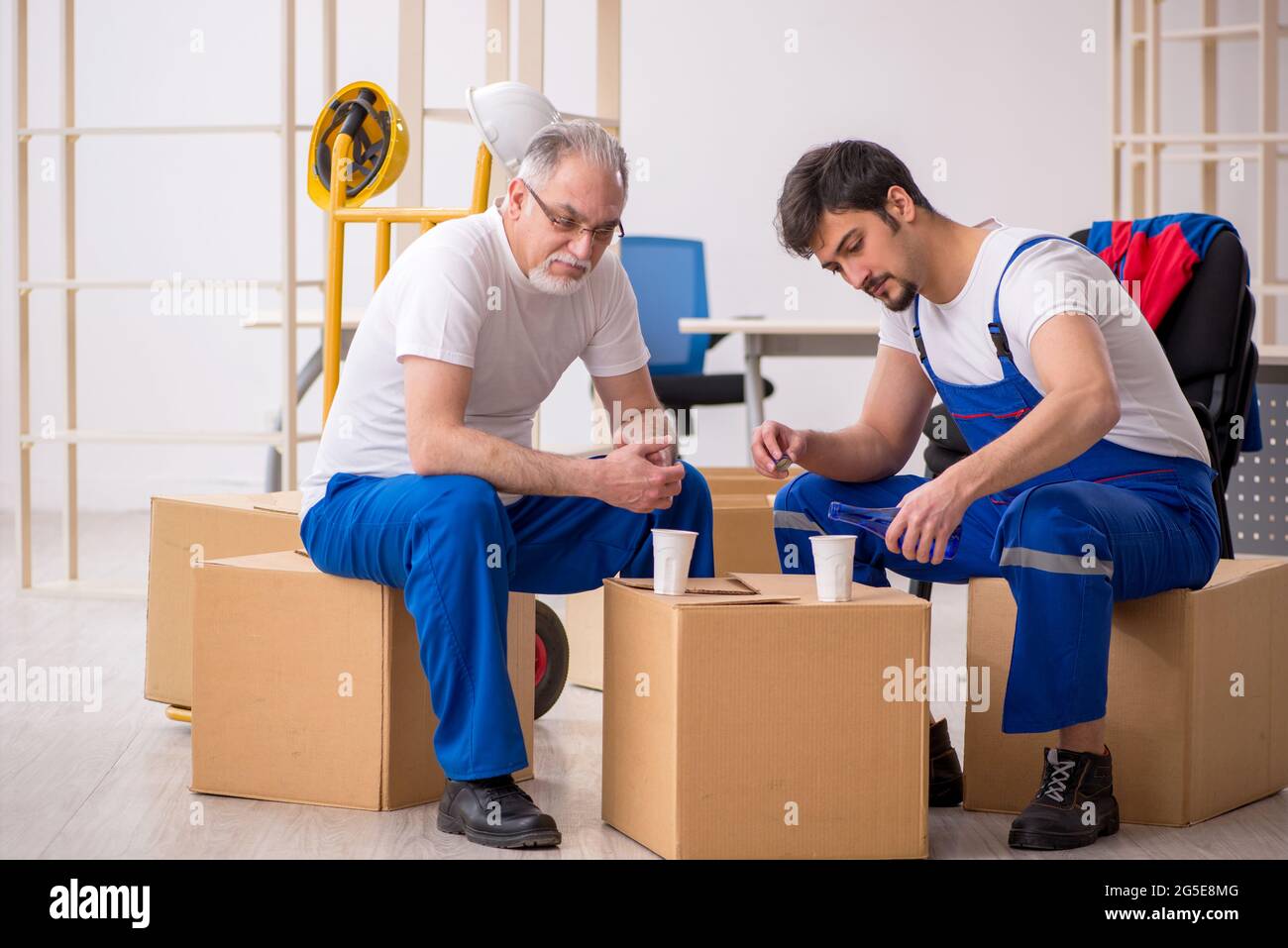 Two professional movers drinking alcohol during break Stock Photo Alamy