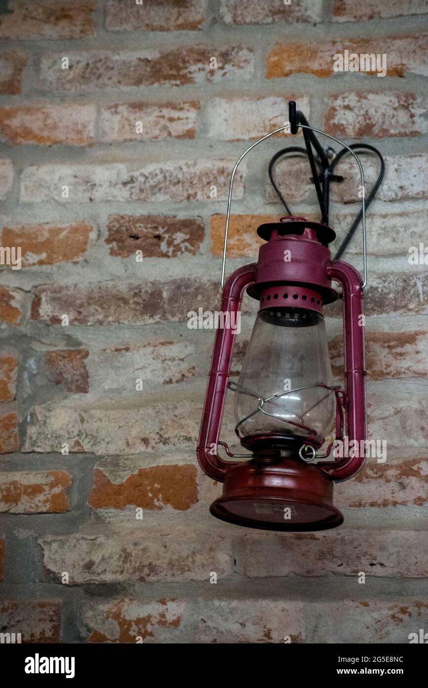 Vintage red lantern hanging on a rustic brick wall Stock Photo