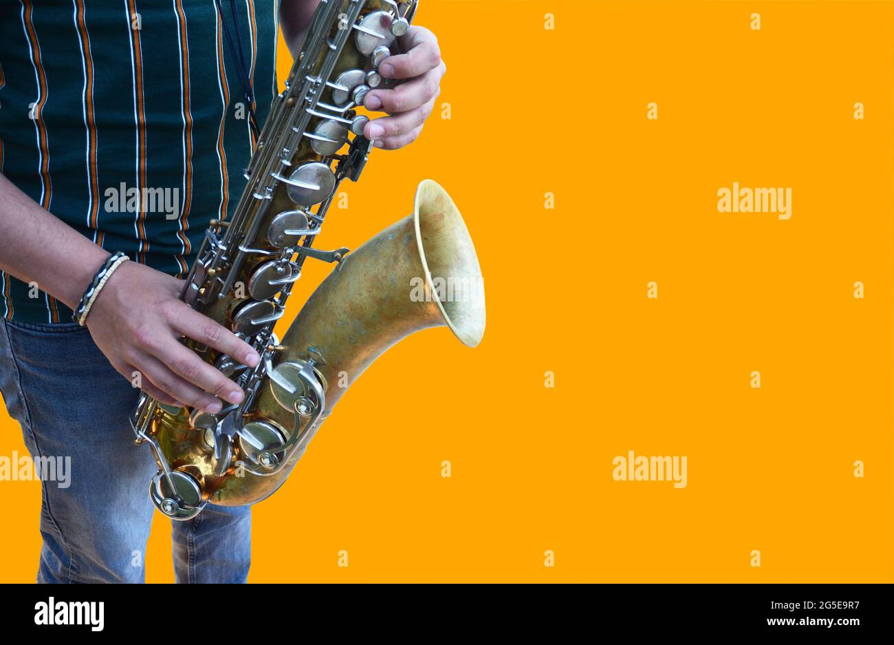 a detail of a saxophone isolated on a orange background Stock Photo
