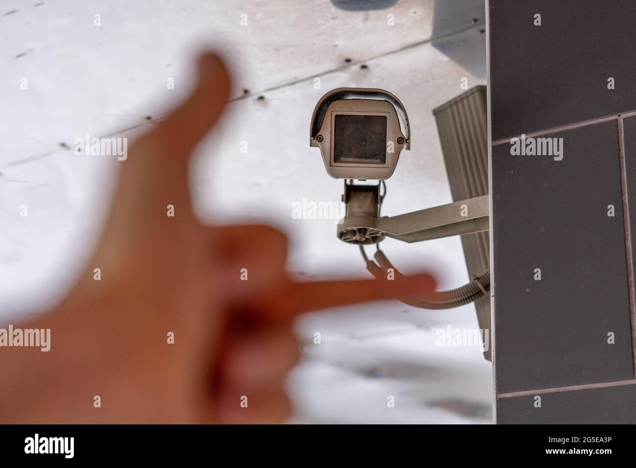 fpv hand show middle finger to cctv camera in public city street Stock Photo