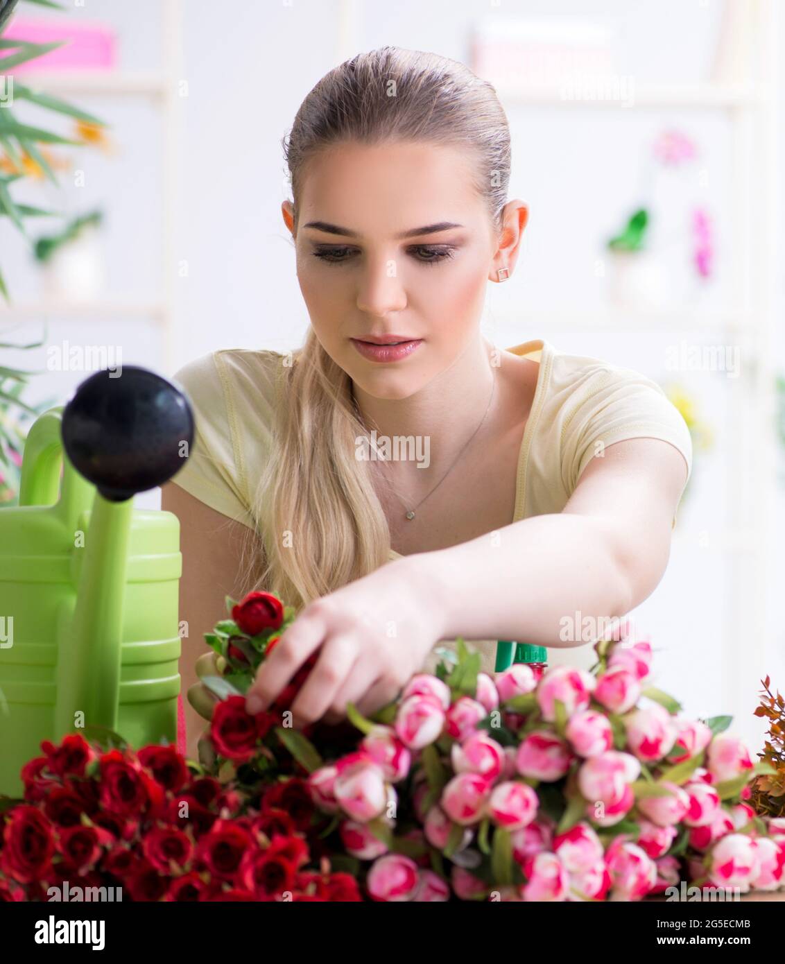 The young woman watering plants in her garden Stock Photo - Alamy