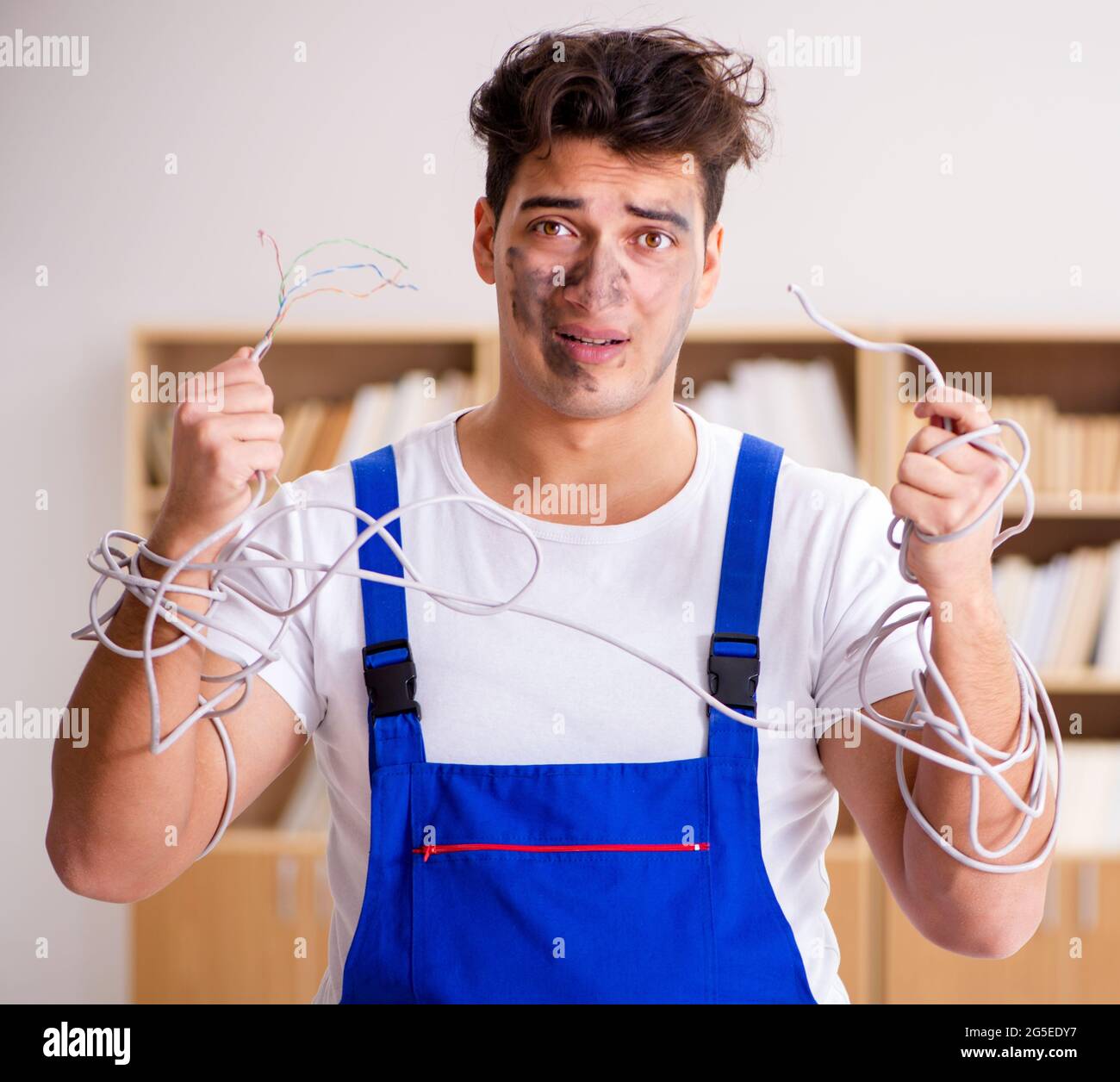 The funny man doing electrical repairs at home Stock Photo