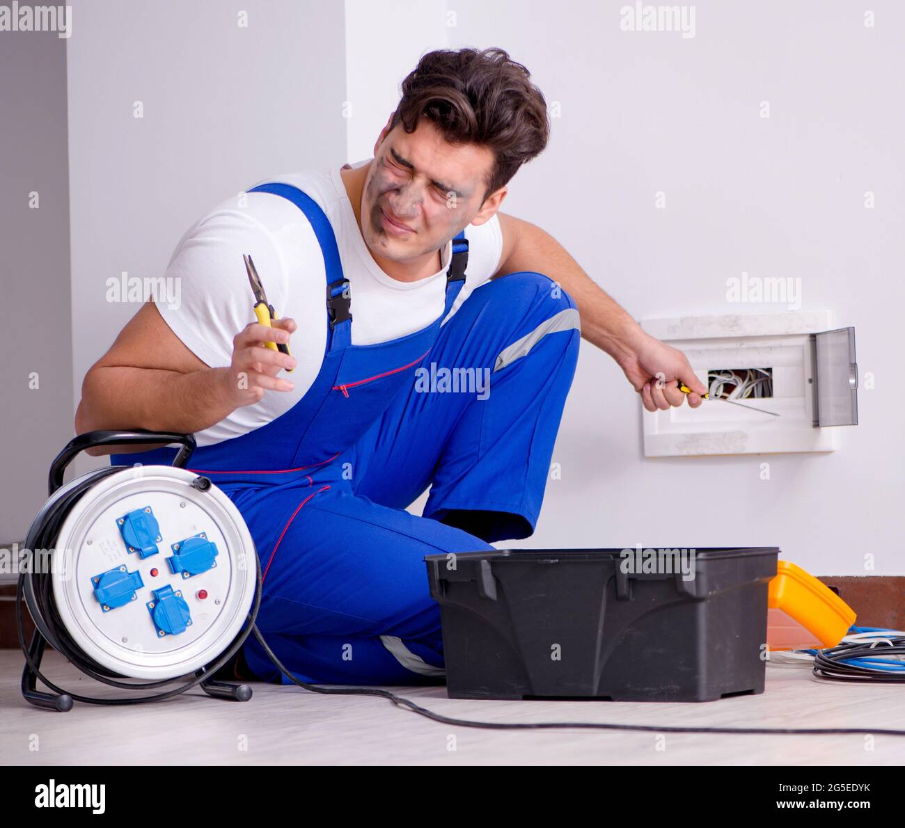 The funny man doing electrical repairs at home Stock Photo