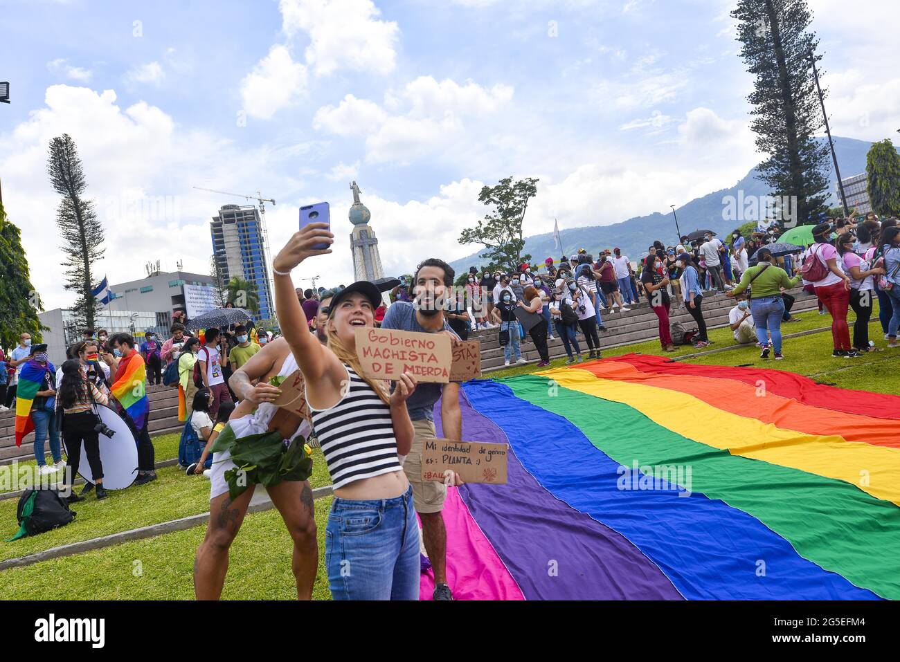 San Salvador, El Salvador. 26th June, 2021. Demonstrators hold up signs against the government's actions that many have signaled as authoritarianism tendencies. Members of the LGBT community march to celebrate pride day months after the Salvadoran Congress archived various law's that would benefit the LGBT community. Credit: Camilo Freedman/ZUMA Wire/Alamy Live News Stock Photo