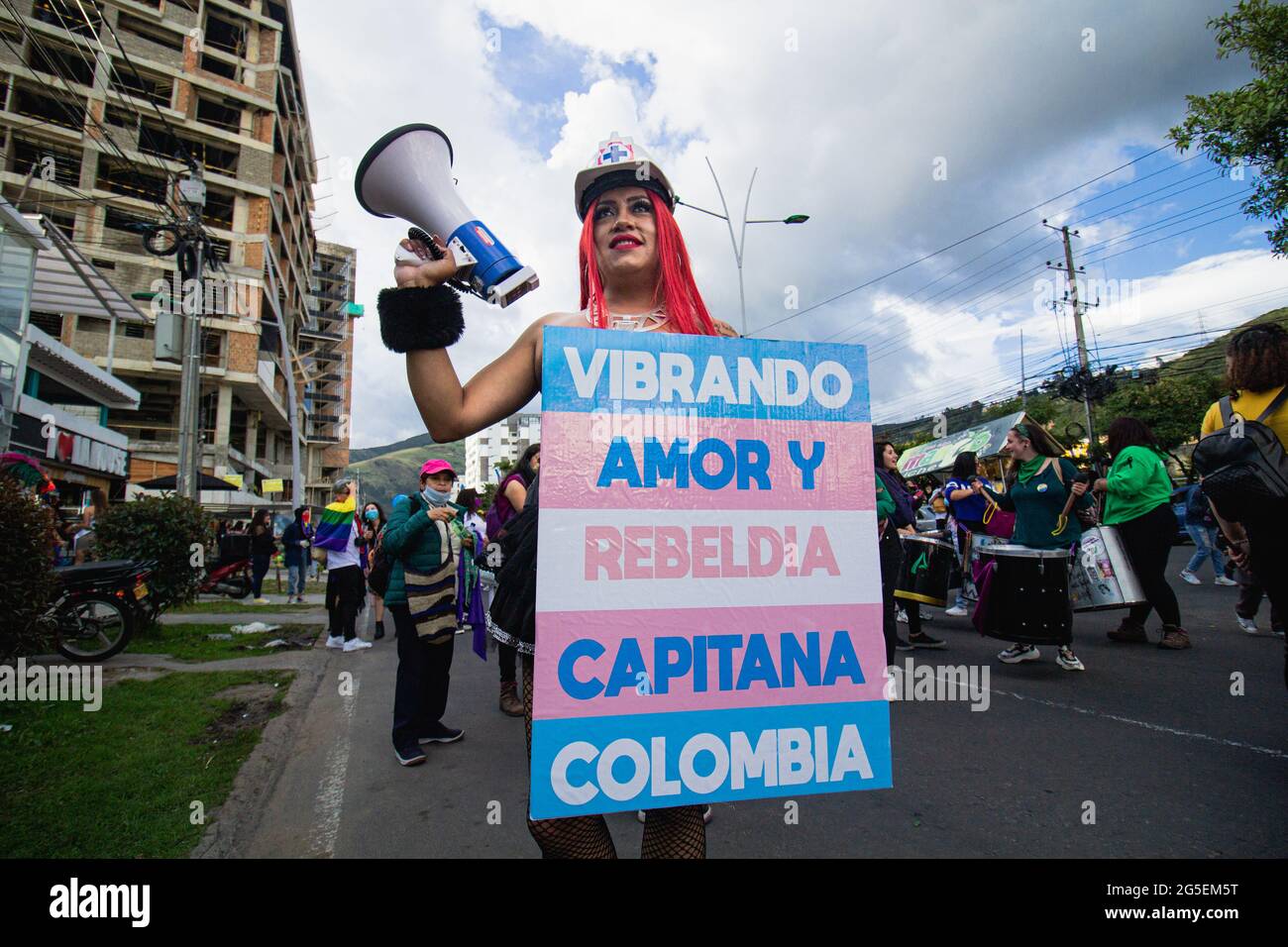 A trans women holds a sign that reads 'Vibrating Love and Rebelion, Captain Colombia' during the annual celebreation of the Pride Parade in demand of LGTBQ rights in Colombia in Pasto, Narino - Colombia on June 25, 2021. Stock Photo