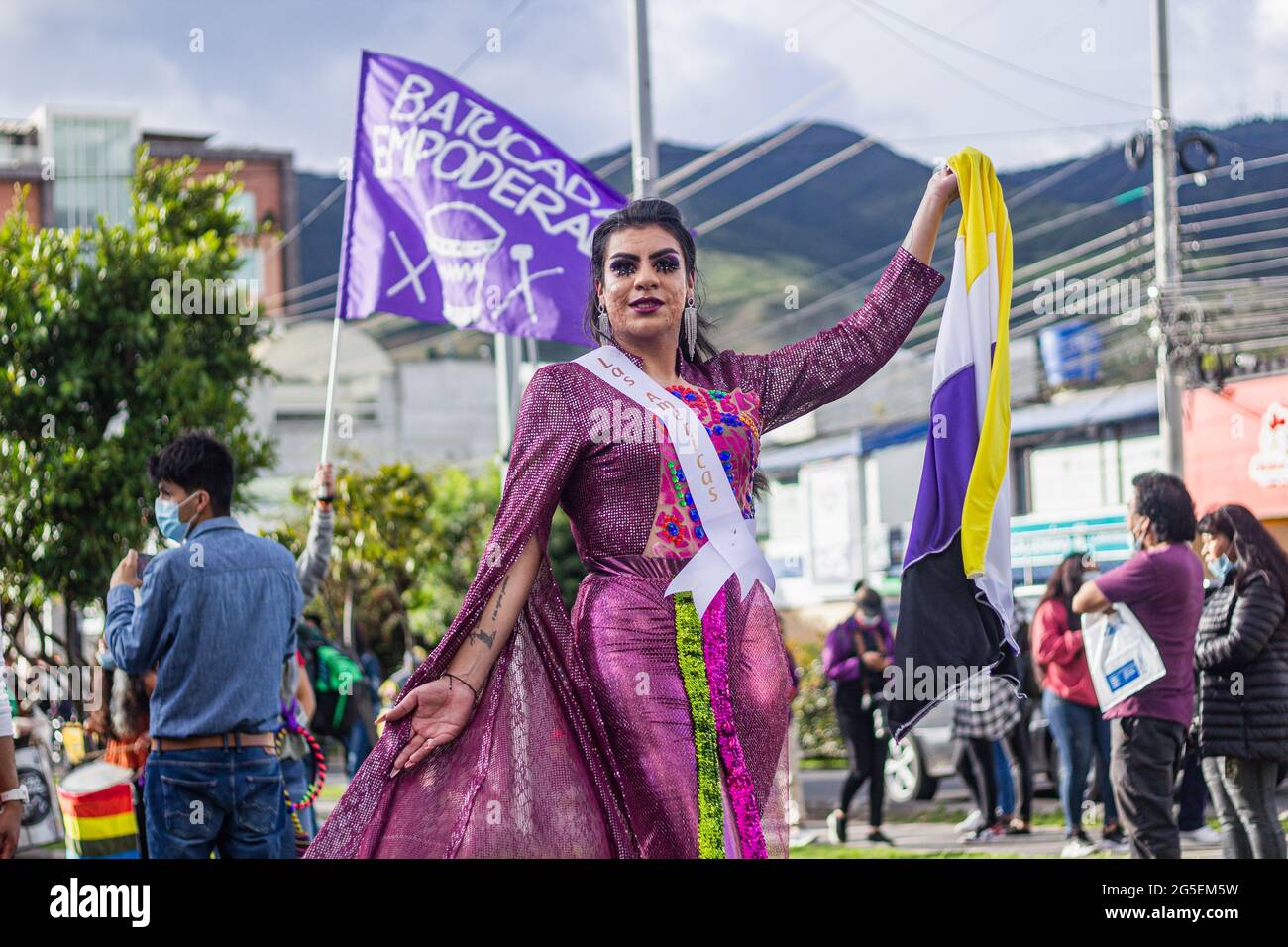 A trans women poses for a photo while wearing a beauty queen dress and ribbon that reads 'The Americas' during the annual celebreation of the Pride Parade in demand of LGTBQ rights in Colombia in Pasto, Narino - Colombia on June 25, 2021. Stock Photo