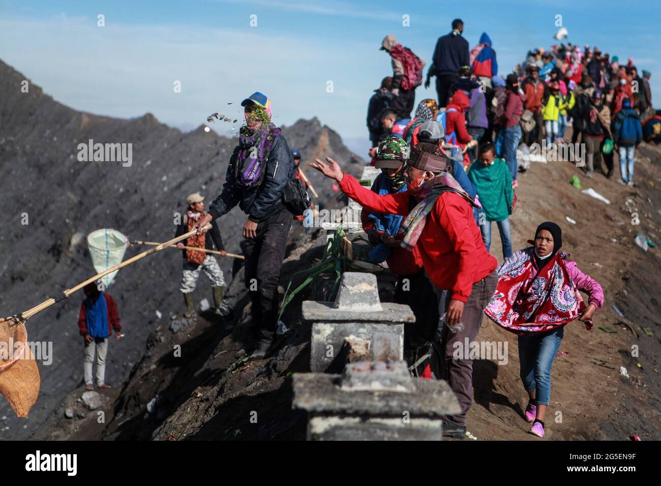 Tenggerese worshippers throw money and vegetable as offerings during the Yadnya Kasada Festival at crater of Mount Bromo amid the coronavirus pandemic. Tenggerese people are a Javanese ethnic group in Eastern Java who claimed to be the descendants of the Majapahit princess. Their population of roughly 500,000 is centered in the Bromo Tengger Semeru National Park in eastern Java. The most popular ceremony is the Kasada festival, which makes it the most visited tourist attraction in Indonesia. The festival is the main festival of the Tenggerese people and lasts about a month. On the fourteenth Stock Photo