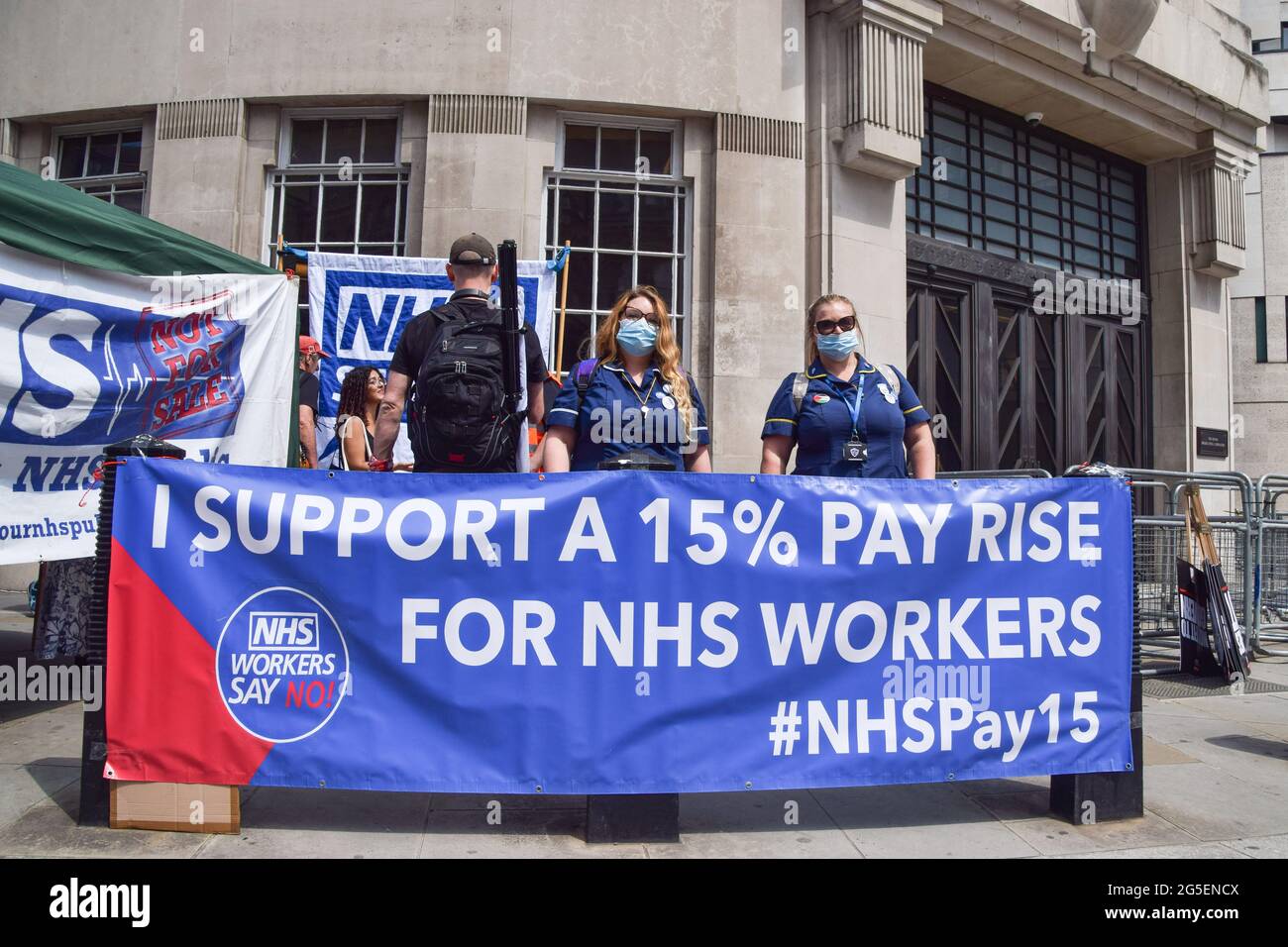 London, UK. 26th June, 2021. Protesters supporting a pay rise for NHS workers stand next to a banner during the demonstration outside BBC headquarters. Several protests took place in the capital, as pro-Palestine, Black Lives Matter, Kill The Bill, Extinction Rebellion, anti-Tory demonstrators, and various other groups marched through Central London. (Photo by Vuk Valcic/SOPA Images/Sipa USA) Credit: Sipa USA/Alamy Live News Stock Photo