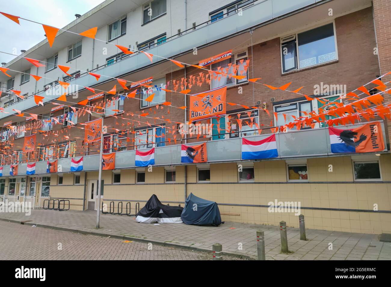 Dutch buildings in a street are decorated with flags to support the Dutch national soccer team. Stock Photo