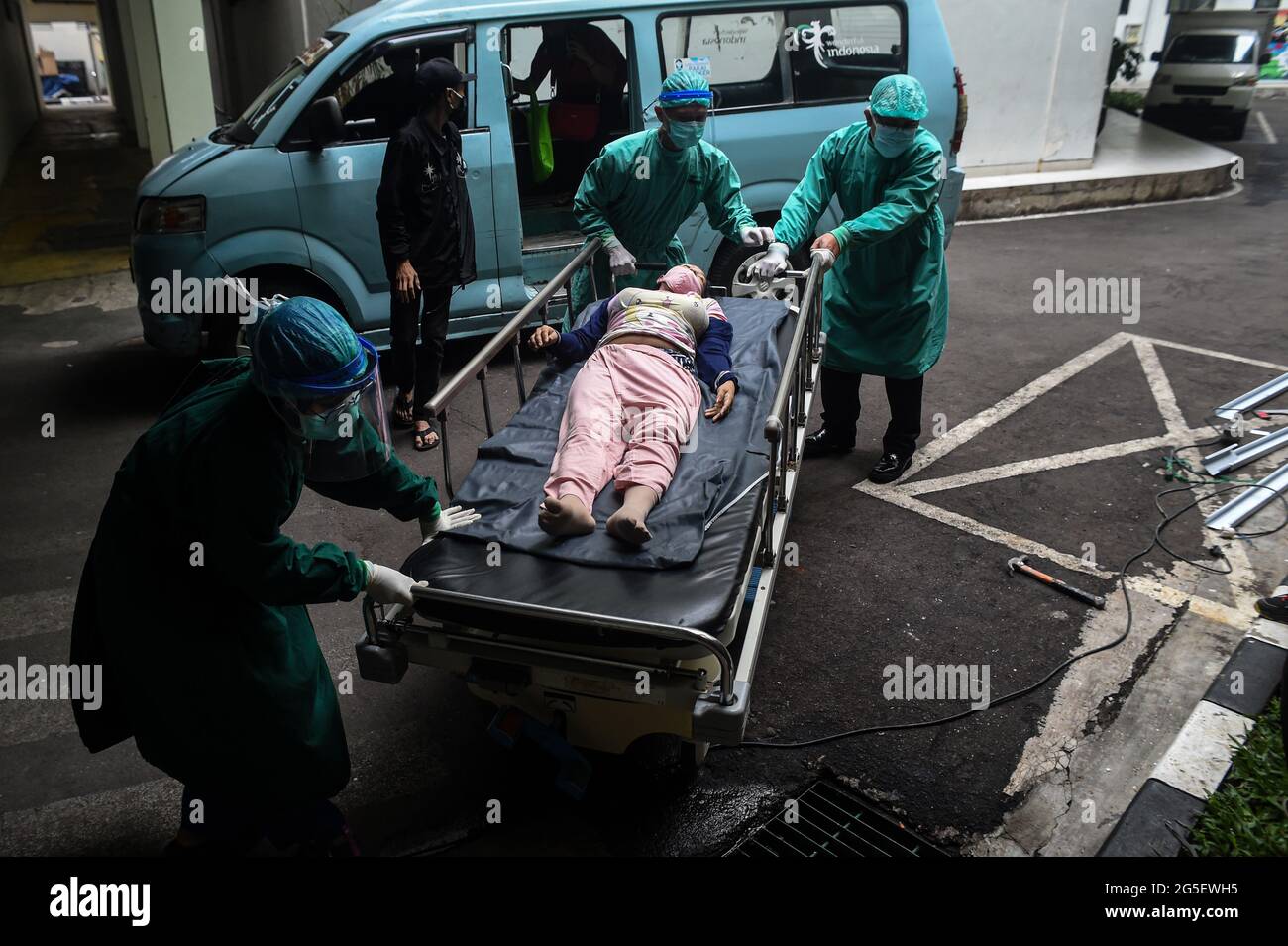 Jakarta, Indonesia. 24th June, 2021. Health workers transfer a patient with high fever in Jakarta, Indonesia, on June 24, 2021. The Health Ministry said on June 26, 2021 that the country recorded 21,095 new COVID-19 cases in the past 24 hours, the highest daily spike since March last year when the first COVID-19 case was detected in the country, bringing the total national tally to 2,093,962. Credit: Agung Kuncahya B./Xinhua/Alamy Live News Stock Photo