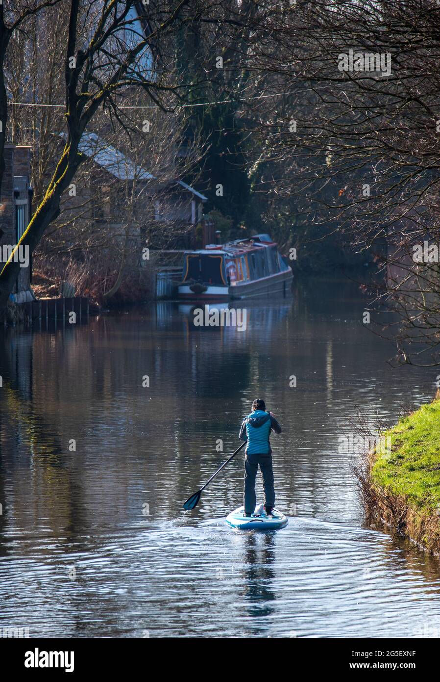 A paddle boarder sailing along the Leeds Liverpool canal Stock Photo