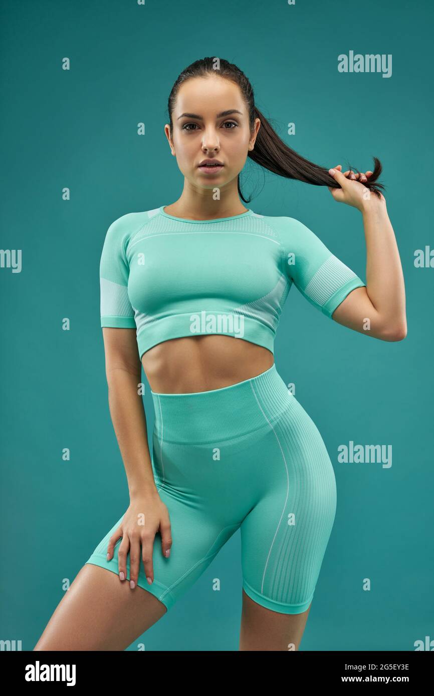 Beautiful young woman in sportswear holding her ponytail Stock Photo