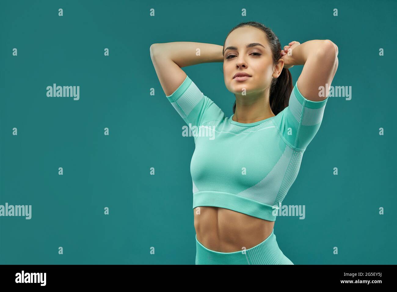 Attractive young woman in sportswear fixing her hair Stock Photo