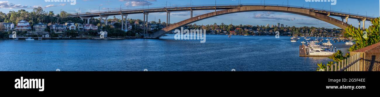 Panorama view of Gladesville Bridge Parramatta river on Sydney harbour foreshore  NSW Australia. Boats Yachts and ferry with luxury houses on the bay Stock Photo