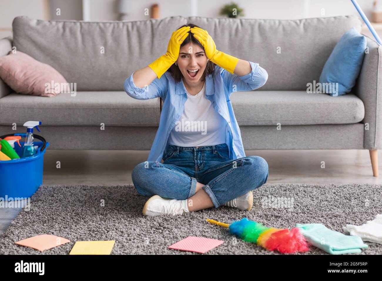Angry woman screaming tired of cleanup, wearing rubber gloves and ...