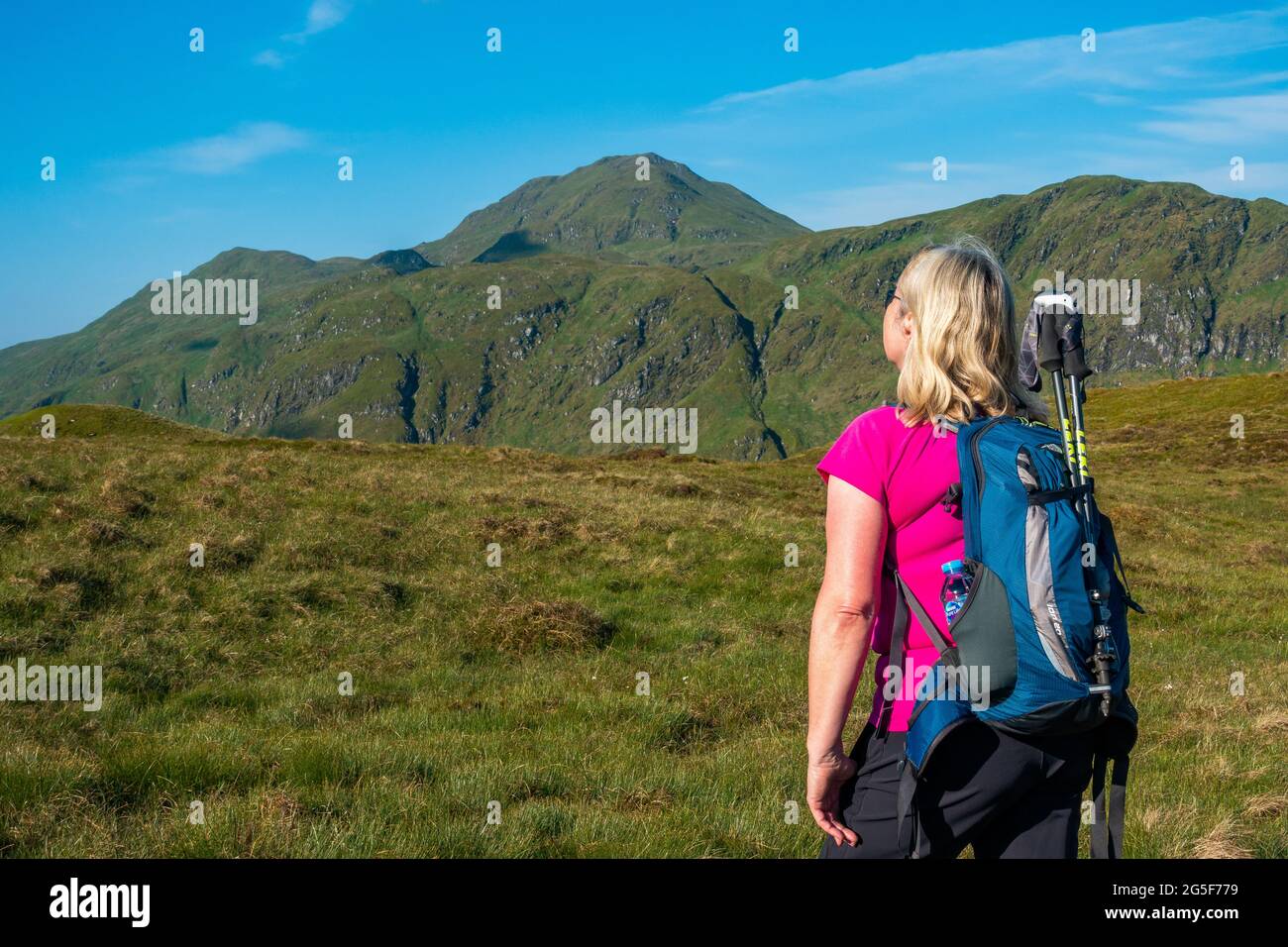 Walker in front of the Tarmachan ridge, seen from the path to Meall Corranaich, with the munro peak of Meall Nan Tarmachan visible in Scotland Stock Photo