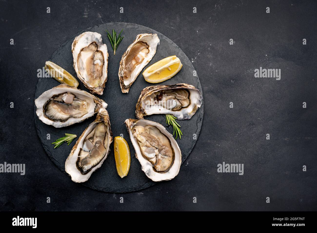 Oysters with lemon on platter Stock Photo