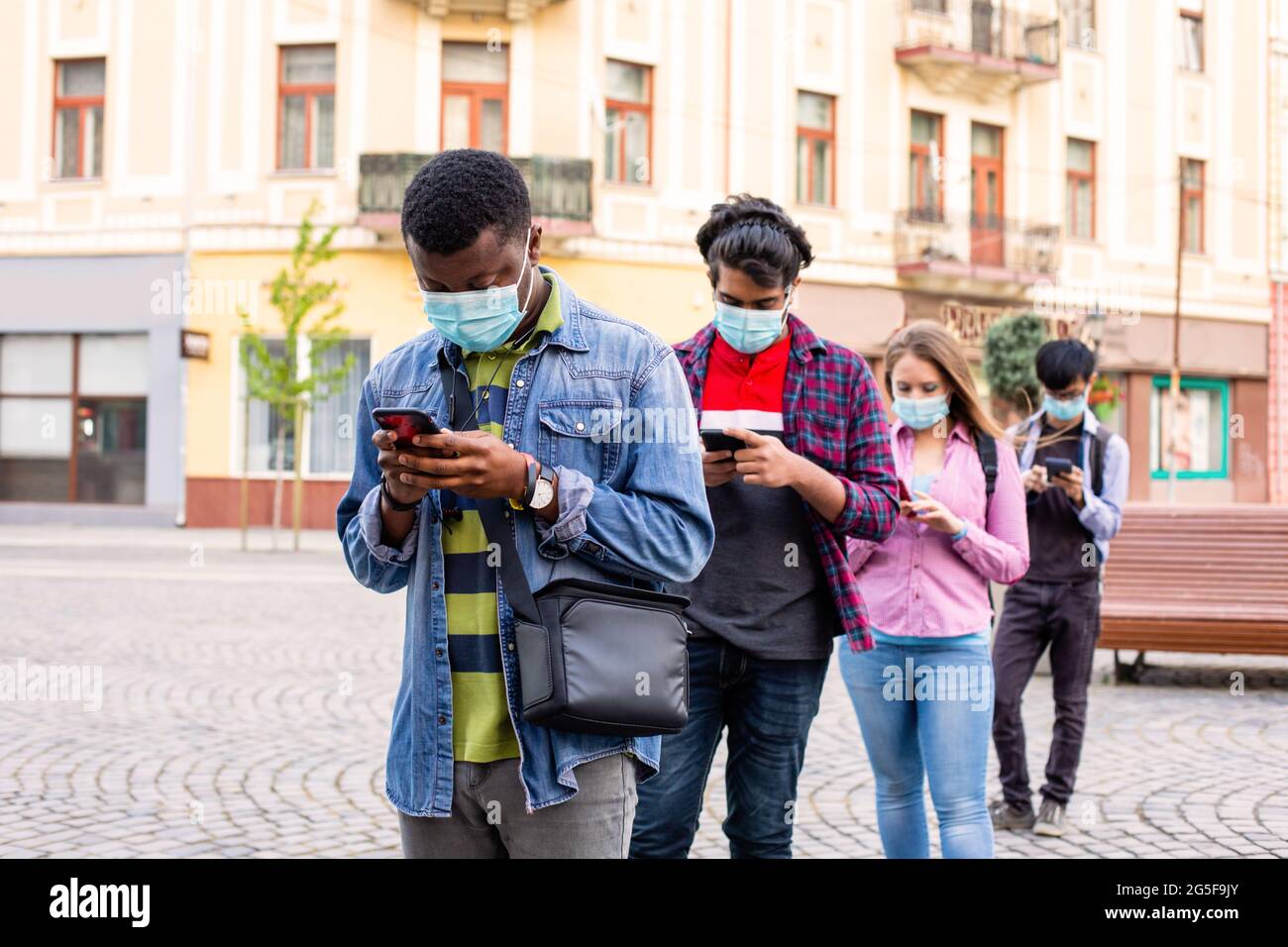 People in masks stand queue keeping social distance Stock Photo - Alamy